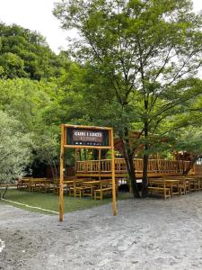 a sign in front of a group of wooden benches at Guri i Lekës Guesthouse in Shkodër