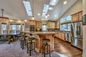 a kitchen with wooden cabinets and a large island with bar stools at Cubby Bear at Heavenly Tahoe - Pets in South Lake Tahoe