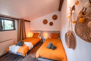 two beds in a room with orange sheets at L'écrin de Bruniquel in Bruniquel +49 photos
