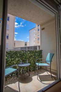 un patio con 2 mesas y sillas en un balcón en Le Cyprès - Charmant, Agréable et Tout Confort en Béziers