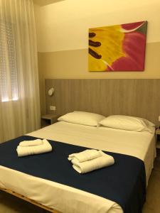 una camera con due letti e asciugamani di Hotel Mare Live a Lido di Jesolo