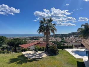 Vilassar de DaltにあるPalm Maresme - Suite with bathroom and living-room and terrasse with ocean views in a private villaの家の前のヤシの木