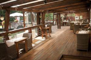um restaurante com pisos e mesas e cadeiras de madeira em Palenica Jelsovce em Jelšovce