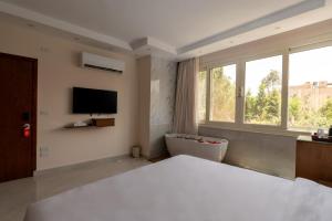 a bedroom with a bed and a tub and a television at Dream Inn in Cairo