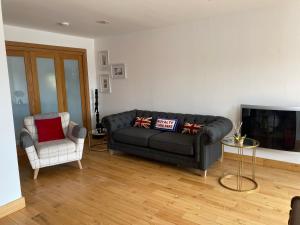 ein Wohnzimmer mit einem Sofa und einem Stuhl in der Unterkunft Marina View in Newcastle upon Tyne