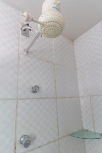 uma casa de banho com chuveiro e luz no tecto em Alfa Hotel Vespasiano em Vespasiano