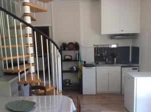 a kitchen with white cabinets and a table and a staircase at le sequoia in Fondettes
