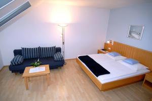 a hotel room with a bed and a couch at Urbarialhof in Illmitz +4 photos