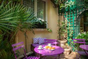 uma mesa roxa com uma taça de fruta no pátio em Hôtel Galileo Champs Elysées em Paris