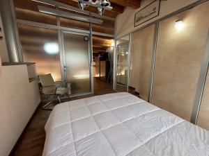 a bedroom with a large white bed and a chair at La Meridiana in Augusta