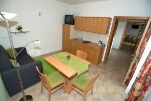 a living room with a table and a couch and a kitchen at Urbarialhof in Illmitz