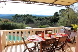 una mesa y sillas en un balcón con vistas en Villa Nassalia, en Lorgues