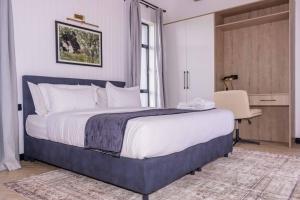 a bedroom with a large bed and a desk at Tufaha Resort in Nanyuki