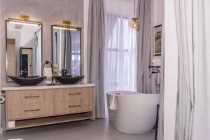 a bathroom with two sinks and a large mirror at Tufaha Resort in Nanyuki +30 photos