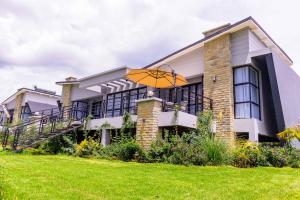 a house with an umbrella on a lawn at Tufaha Resort in Nanyuki