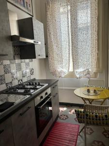 a kitchen with a stove and a table at La Meridiana in Augusta