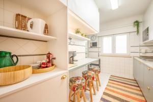 リスボンにあるGuestReady - A Cosy Retreat in Lumiarの白いカウンターとスツール付きのキッチン