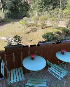 two tables and chairs on a patio with a garden at Le Pélican in Saint-Georges-de-Didonne +6 photos