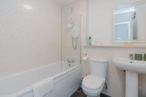 een witte badkamer met een toilet en een wastafel bij GuestReady - Restful stay near Edinburgh Castle in Edinburgh