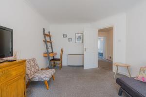 een woonkamer met een tv en een bank en een stoel bij GuestReady - Restful stay near Edinburgh Castle in Edinburgh