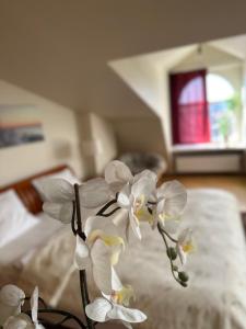 里加Old Town Apartment with Sauna的一束白色的兰花放在床上