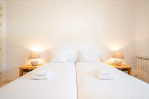 2 aparte bedden in een kamer met 2 lampen bij GuestReady - Relaxation near Carcavelos Beach in Carcavelos