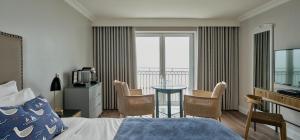 ein Hotelzimmer mit einem Bett und einem Tisch mit Stühlen in der Unterkunft Bayview Hotel in Ballycotton