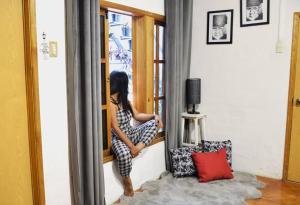 a woman is sitting on a window sill at Espacioso moderno y bien ubicado in Oaxaca City