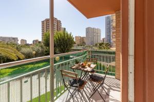 a balcony with a table and chairs and a view of the city at Cozy stay in Pobla Farnals - 15 min from Valencia in Puebla de Farnals