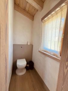 a small bathroom with a toilet and a window at Cabañas Agotzenea in Zubiri