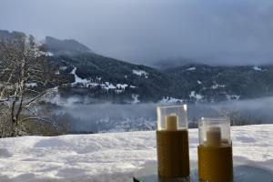 two candles in glass containers in the snow at Stylish place-Amazing Views-3 main lifts, Apt design- vue splendide-3 Telecabines in Samoëns