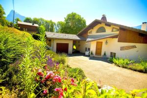 a house with a driveway and flowers in the yard at Stylish place-Amazing Views-3 main lifts, Apt design- vue splendide-3 Telecabines in Samoëns