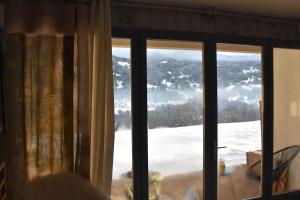 a view of a snow covered mountain through a window at Stylish place-Amazing Views-3 main lifts, Apt design- vue splendide-3 Telecabines in Samoëns