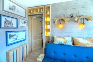 a blue couch in a room with a wall at Stylish place-Amazing Views-3 main lifts, Apt design- vue splendide-3 Telecabines in Samoëns