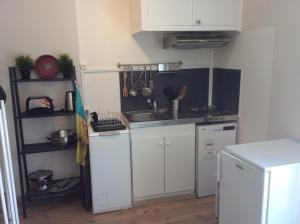 a small kitchen with white cabinets and a sink at le sequoia in Fondettes +5 photos