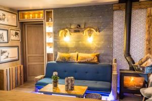 a bedroom with a blue couch and a fireplace at Stylish place-Amazing Views-3 main lifts, Apt design- vue splendide-3 Telecabines in Samoëns