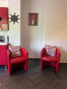 duas cadeiras vermelhas sentadas uma ao lado da outra num quarto em Springhome Newport em Newport