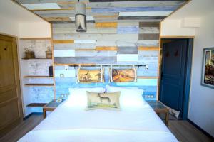 a bedroom with a white bed and a blue wall at Stylish place-Amazing Views-3 main lifts, Apt design- vue splendide-3 Telecabines in Samoëns