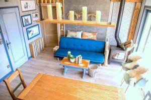 a living room with a blue couch and a table at Stylish place-Amazing Views-3 main lifts, Apt design- vue splendide-3 Telecabines in Samoëns
