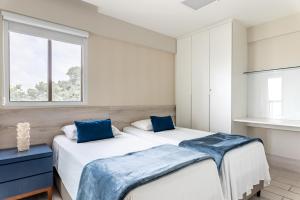 due letti in una camera da letto con finestra di La Fleur Polinésia a Porto De Galinhas Altre 51 foto