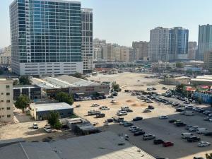 a parking lot with cars parked in a city at Royal Suite: King Comfort in Ajman 