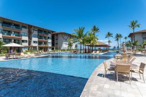 a pool at a resort with chairs and tables at La Fleur Polinésia in Porto De Galinhas