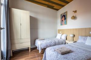 um quarto com duas camas e uma cómoda em BaruHaus Conde Luna em León