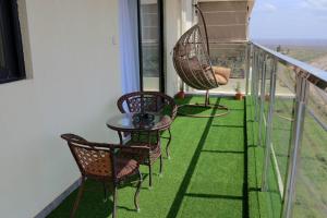 un balcon avec des chaises et une table sur un balcon dans l'établissement Favorite staycation, à Nairobi