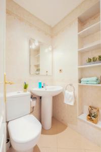 a bathroom with a white toilet and a sink at Summerlandrota La Caleta in Rota