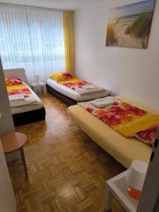 a room with three beds and a table at 98, Bergblick, 2 Schlafzimmer, Dusche , WC, Küche, Wohnzimmer in Bad Reichenhall