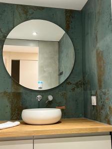 La salle de bains est pourvue d'un lavabo et d'un miroir. dans l'établissement The Wave Village Naturiste Port Ambonne Cap d Agde, au Cap d'Agde