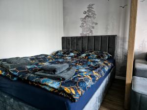 a bed with blankets and pillows on top of it at Apartmán Lesa Brezno in Brezno