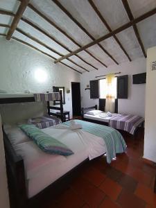 圣希尔Hotel Campestre Casona del Camino Real的一间房间里有两张床的卧室