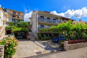 a building with a car parked in front of it at Apartman Mediteran in Crikvenica